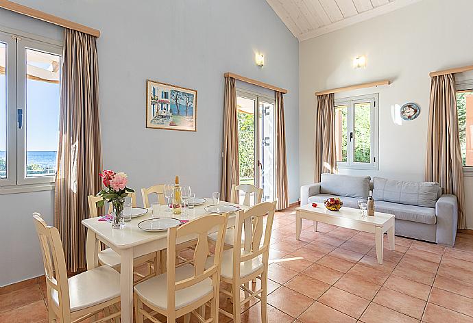 Open-plan living room with sofa, dining area, kitchen, mezzanine, A/C, WiFi internet, satellite TV, and sea views . - Antigoni Beach House . (Fotogalerie) }}