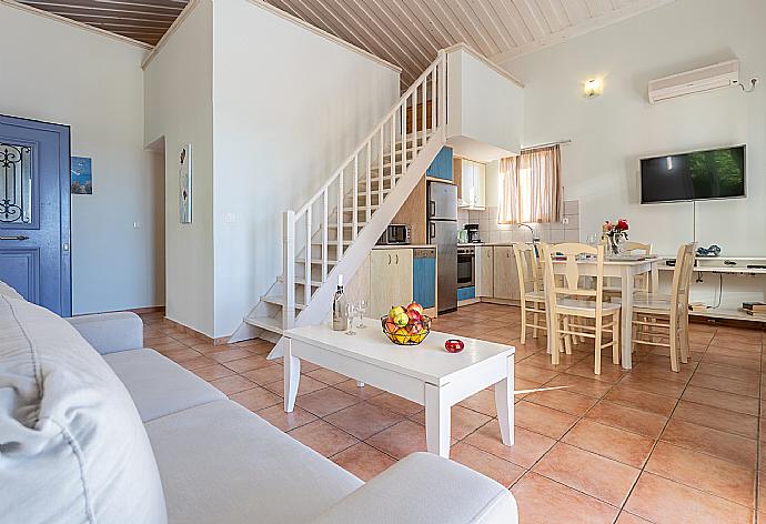 Open-plan living room with sofa, dining area, kitchen, mezzanine, A/C, WiFi internet, satellite TV, and sea views . - Antigoni Beach House . (Fotogalerie) }}