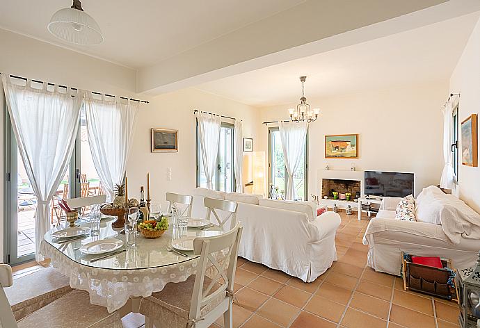 Open-plan living room with sofas, dining area, kitchen, ornamental fireplace, A/C, WiFi internet, satellite TV, and terrace access . - Villa Nora . (Galleria fotografica) }}