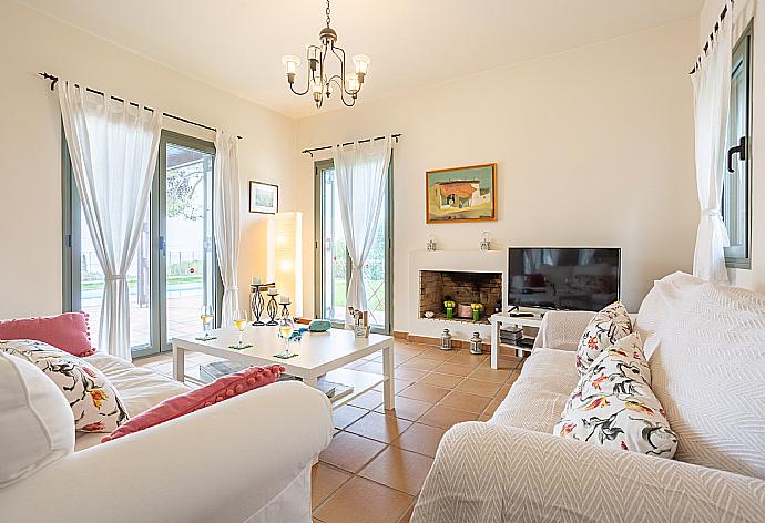 Open-plan living room with sofas, dining area, kitchen, ornamental fireplace, A/C, WiFi internet, satellite TV, and terrace access . - Villa Nora . (Galleria fotografica) }}