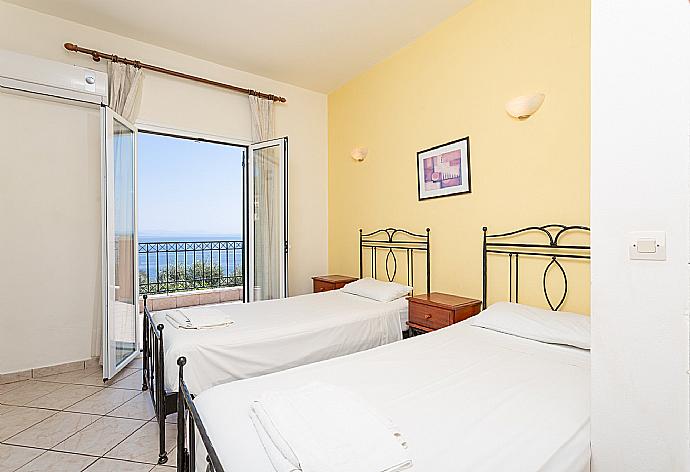 Twin bedroom with A/C and balcony access . - Villa Vasillis . (Photo Gallery) }}