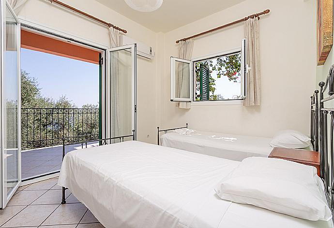 Twin bedroom with A/C and terrace access . - Villa Vasillis . (Photo Gallery) }}