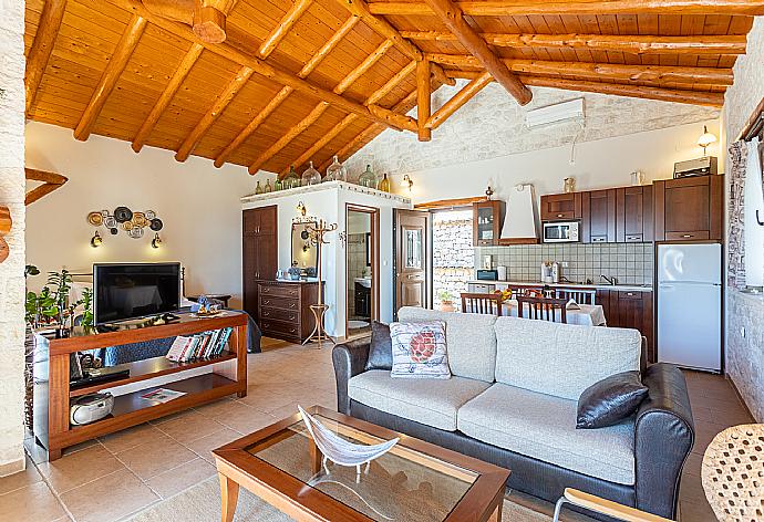 Open-plan living room with sofa, dining area, kitchen, double bed, ornamental fireplace, A/C, WiFi internet, and satellite TV . - Villa Nionios . (Galerie de photos) }}