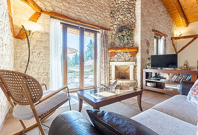 Open-plan living room with sofa, dining area, kitchen, double bed, ornamental fireplace, A/C, WiFi internet, and satellite TV . - Villa Nionios . (Galerie de photos) }}