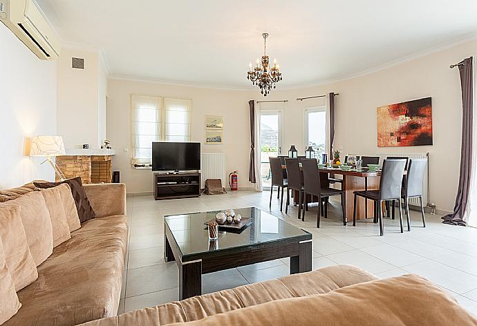 Open-plan living room with sofas, dining area, kitchen, ornamental fireplace, A/C, WiFi internet, satellite TV, and terrace access with sea views . - Villa Georgios . (Galería de imágenes) }}