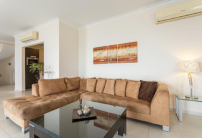 Open-plan living room with sofas, dining area, kitchen, ornamental fireplace, A/C, WiFi internet, satellite TV, and terrace access with sea views . - Villa Georgios . (Fotogalerie) }}