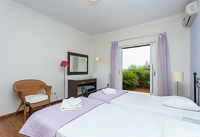 Twin bedroom with en suite bathroom, A/C, and terrace access . - Villa Georgios . (Photo Gallery) }}