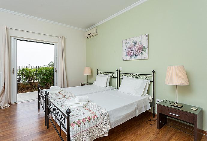 Twin bedroom with en suite bathroom, A/C, and terrace access . - Villa Georgios . (Fotogalerie) }}