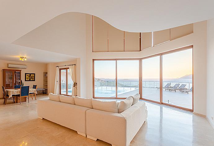 Open-plan living room with sofas, dining area, kitchen, A/C, WiFi internet, satellite TV, DVD player, and terrace access with panoramic sea views . - Villa Lara . (Photo Gallery) }}