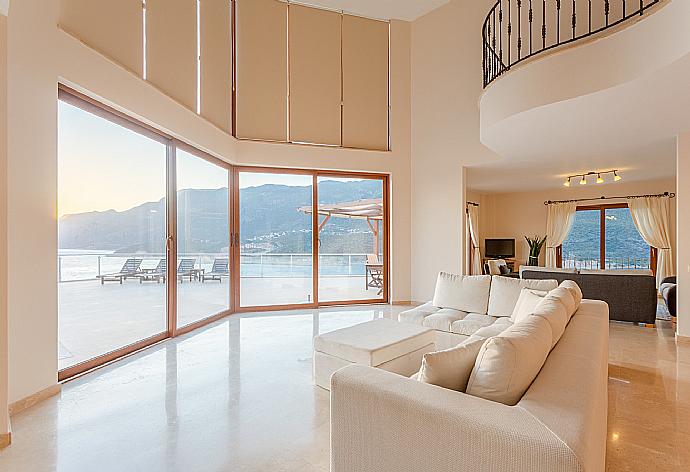 Open-plan living room with sofas, dining area, kitchen, A/C, WiFi internet, satellite TV, DVD player, and terrace access with panoramic sea views . - Villa Lara . (Photo Gallery) }}