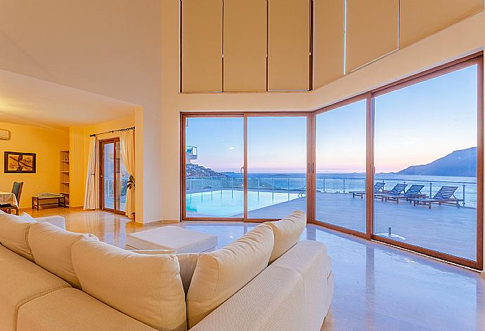 Open-plan living room with sofas, dining area, kitchen, A/C, WiFi internet, satellite TV, DVD player, and terrace access with panoramic sea views . - Villa Lara . (Photo Gallery) }}