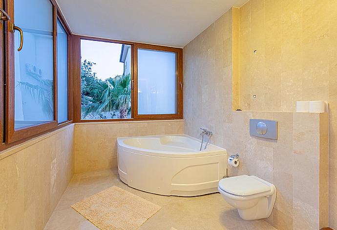 En suite bathroom with spa bath and shower . - Villa Lara . (Photo Gallery) }}