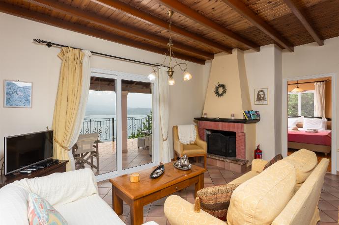 Living room on first floor with sofas, dining area, ornamental fireplace, WiFi internet, satellite TV, and sea views . - Villa Eleni . (Photo Gallery) }}