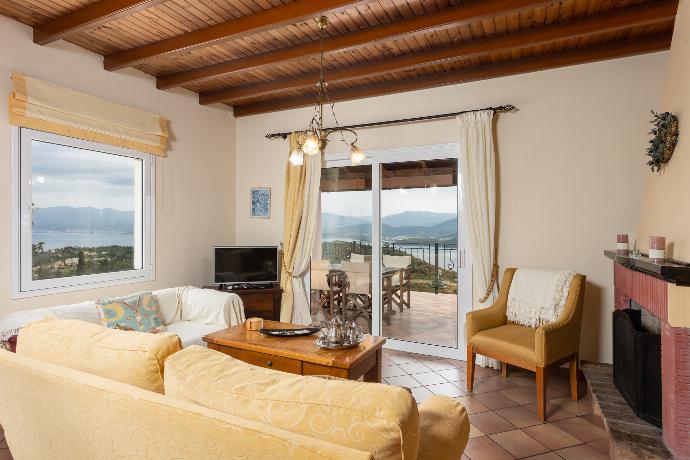 Living room on first floor with sofas, dining area, ornamental fireplace, WiFi internet, satellite TV, and sea views . - Villa Eleni . (Photo Gallery) }}