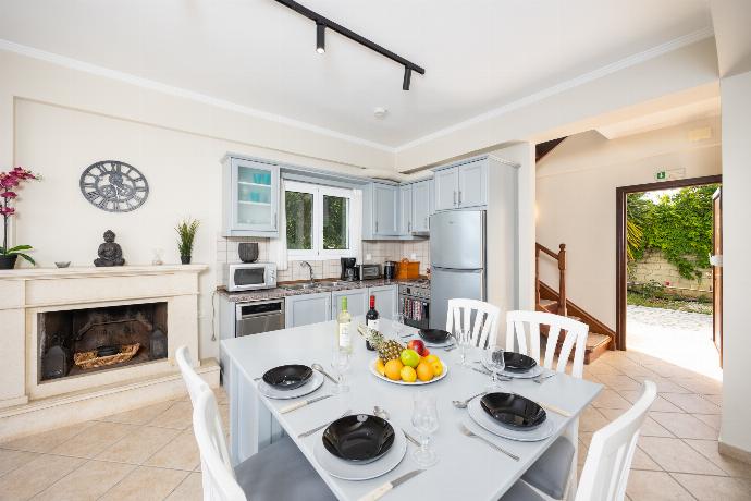 Open-plan living room with sofa, dining area, kitchen, WiFi internet, satellite TV, and sea views . - Villa Eleni Agios Stephanos . (Γκαλερί Φωτογραφιών) }}