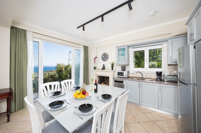 Open-plan living room with sofa, dining area, kitchen, WiFi internet, satellite TV, and sea views . - Villa Eleni Agios Stephanos . (Γκαλερί Φωτογραφιών) }}