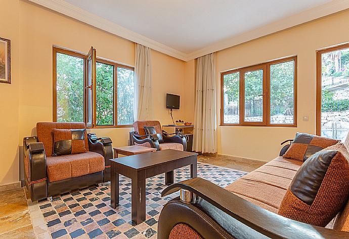 Open-plan living room with sofas, dining area, kitchen, A/C, WiFi internet, satellite TV, and pool terrace access . - Villa Arykanoos . (Галерея фотографий) }}