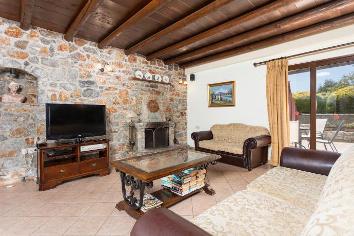 Open-plan living room with sofas, dining area, kitchen, ornamental fireplace, A/C, WiFi internet, and satellite TV . - Villa Melina . (Fotogalerie) }}