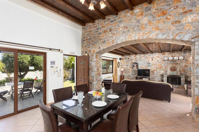 Open-plan living room with sofas, dining area, kitchen, ornamental fireplace, A/C, WiFi internet, and satellite TV . - Villa Melina . (Fotogalerie) }}