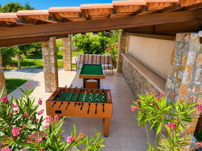 Covered outdoor games area with table football, pool table, and lush garden surroundings. . - Villa Nineta . (Photo Gallery) }}