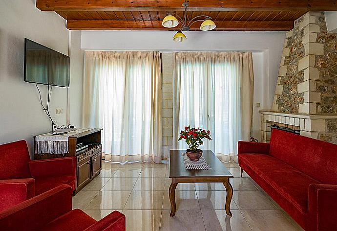 Open-plan living room with sofas, dining area, kitchen, ornamental fireplace, WiFi internet, satellite TV, DVD player, and terrace access  . - Villa Nikolas . (Galerie de photos) }}