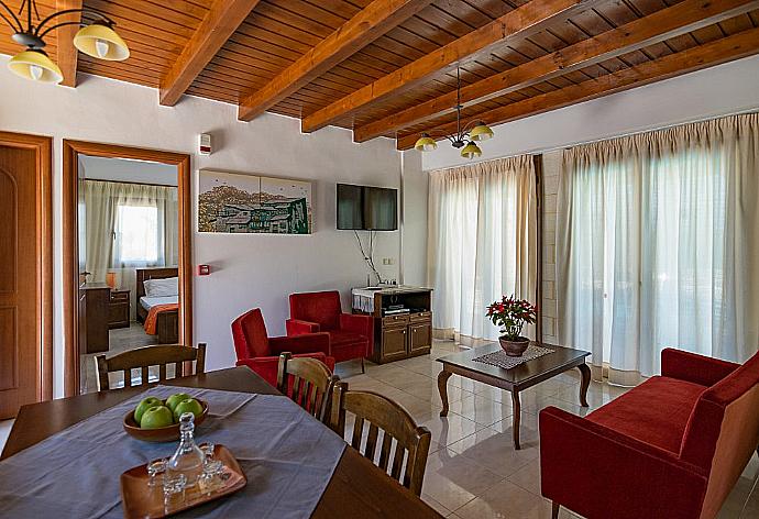 Open-plan living room with sofas, dining area, kitchen, ornamental fireplace, WiFi internet, satellite TV, DVD player, and terrace access  . - Villa Nikolas . (Galería de imágenes) }}