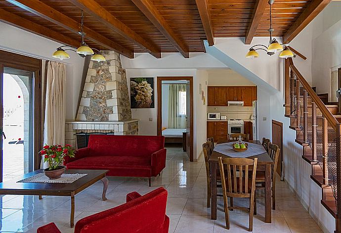 Open-plan living room with sofas, dining area, kitchen, ornamental fireplace, WiFi internet, satellite TV, DVD player, and terrace access  . - Villa Nikolas . (Galería de imágenes) }}