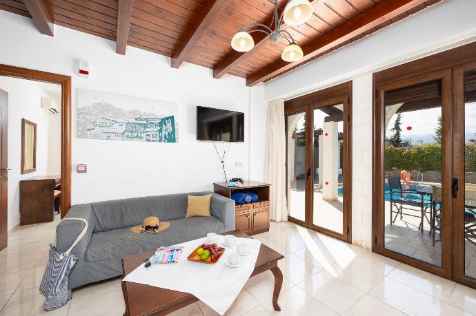Open-plan living room with sofa, dining area, kitchen, ornamental fireplace, WiFi internet, and satellite TV . - Villa Nikolas . (Galleria fotografica) }}
