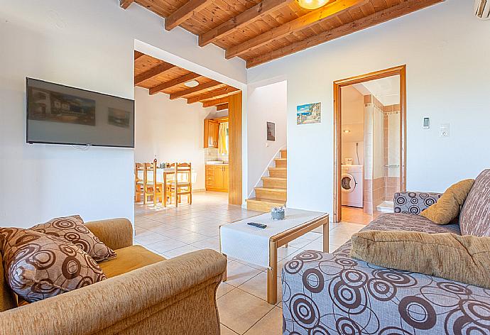 Open-plan living room with sofas, dining area, kitchen, A/C, WiFi internet, satellite TV, DVD player, and terrace access . - Andreas Beach Villa . (Fotogalerie) }}