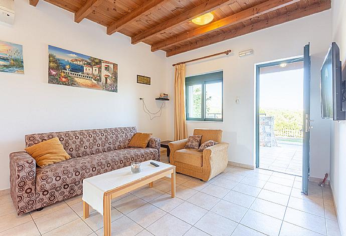 Open-plan living room with sofas, dining area, kitchen, A/C, WiFi internet, satellite TV, DVD player, and terrace access . - Andreas Beach Villa . (Fotogalerie) }}