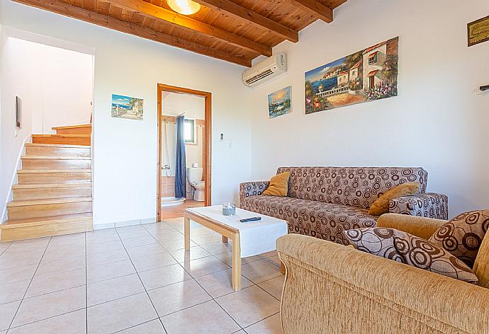 Open-plan living room with sofas, dining area, kitchen, A/C, WiFi internet, satellite TV, DVD player, and terrace access . - Andreas Beach Villa . (Fotogalerie) }}