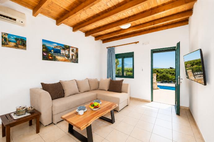 Open-plan living room with sofa, dining area, kitchen, A/C, WiFi internet, and satellite TV . - Andreas Beach Villa . (Fotogalerie) }}