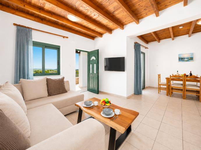 Open-plan living room with sofa, dining area, kitchen, A/C, WiFi internet, and satellite TV . - Andreas Beach Villa . (Fotogalerie) }}