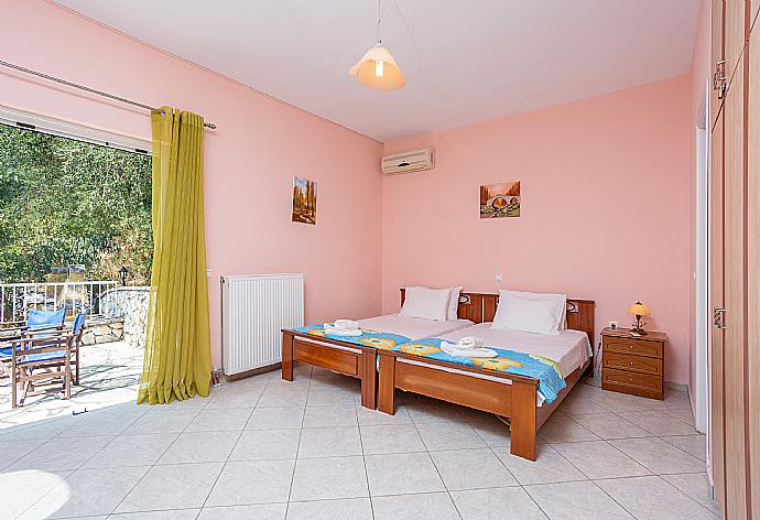 Twin bedroom with en suite bathroom, A/C, and upper terrace access with sea views . - Villa Petros . (Photo Gallery) }}