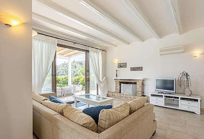 Open-plan living room with sofa, dining area, kitchen, ornamental fireplace, A/C, WiFi internet, satellite TV, and terrace access . - Villa Zacharenia . (Galleria fotografica) }}