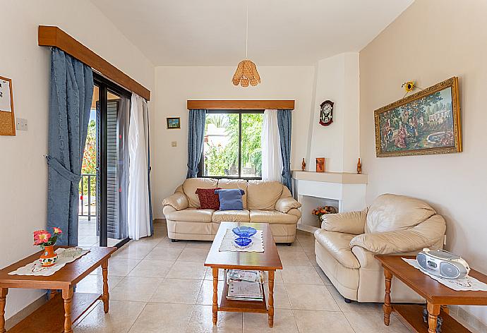 Open-plan living room with sofas, dining area, kitchen, ornamental fireplace, A/C, WiFi internet, satellite TV, DVD player, and terrace access . - Villa Eleni . (Fotogalerie) }}