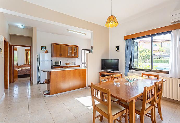 Open-plan living room with sofas, dining area, kitchen, ornamental fireplace, A/C, WiFi internet, satellite TV, DVD player, and terrace access . - Villa Eleni . (Galería de imágenes) }}