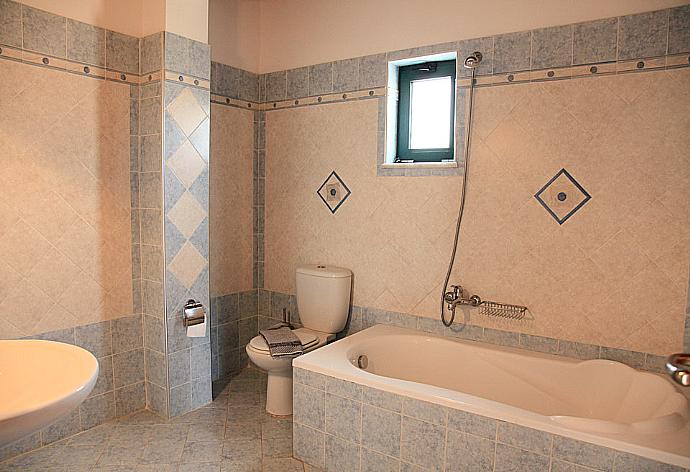 Bathroom with bath and overhead shower . - Theo Beach Villa . (Photo Gallery) }}