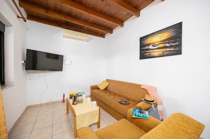 Lower unit: open-plan living room with sofa, dining area, kitchen, A/C, WiFi internet, and satellite TV . - Theo Beach Villa . (Photo Gallery) }}