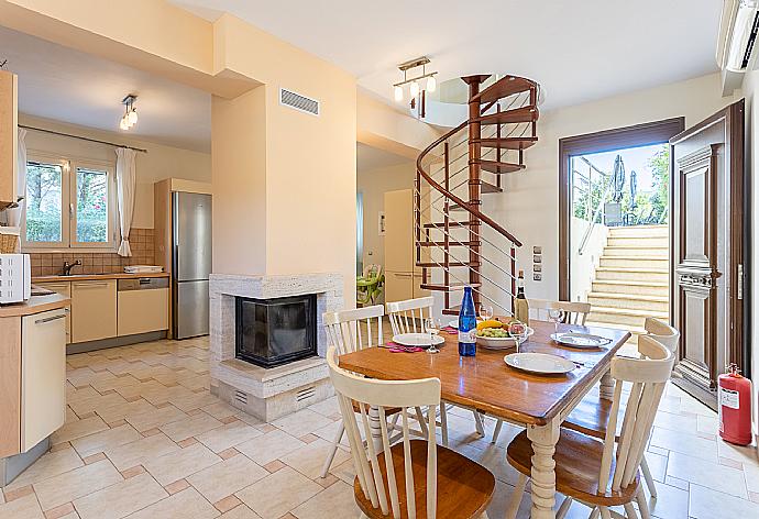 Living area on ground floor with sofa, dining area, kitchen, ornamental fireplace, A/C, and WiFi internet . - Villa Ismini . (Fotogalerie) }}