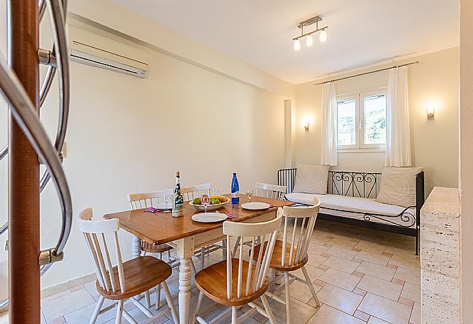 Living area on ground floor with sofa, dining area, kitchen, ornamental fireplace, A/C, and WiFi internet . - Villa Ismini . (Fotogalerie) }}