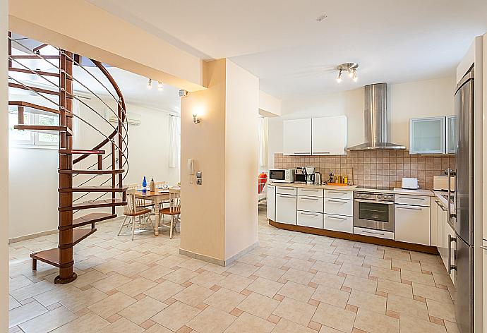 Living area on ground floor with sofa, dining area, kitchen, ornamental fireplace, A/C, and WiFi internet . - Villa Semeli . (Fotogalerie) }}