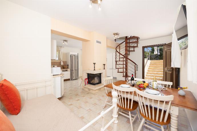 Open-plan living room with sofa, dining area, kitchen, ornamental fireplace, A/C, WiFi internet, and satellite TV . - Villa Semeli . (Photo Gallery) }}