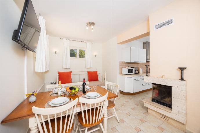 Open-plan living room with sofa, dining area, kitchen, ornamental fireplace, A/C, WiFi internet, and satellite TV . - Villa Semeli . (Photo Gallery) }}
