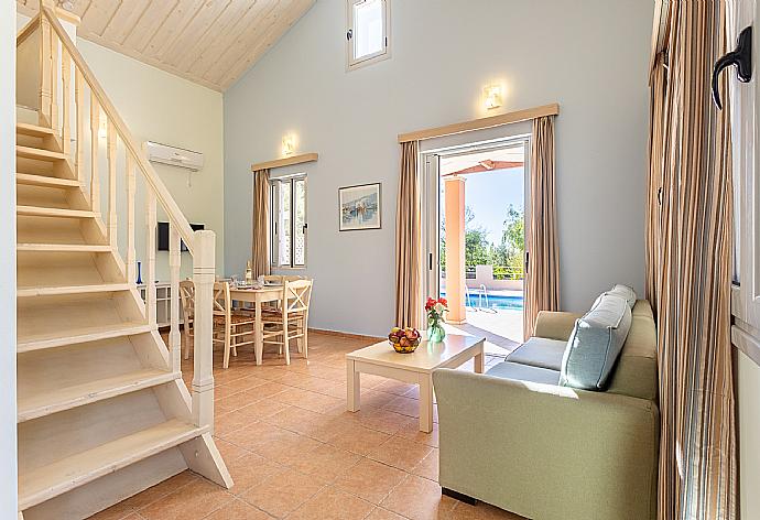 Open-plan living room with sofa, dining area, kitchen, mezzanine, A/C, WiFi internet, satellite TV, and terrace access . - Nafsika Beach House . (Fotogalerie) }}