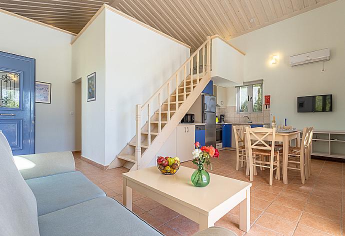 Open-plan living room with sofa, dining area, kitchen, mezzanine, A/C, WiFi internet, satellite TV, and terrace access . - Nafsika Beach House . (Fotogalerie) }}