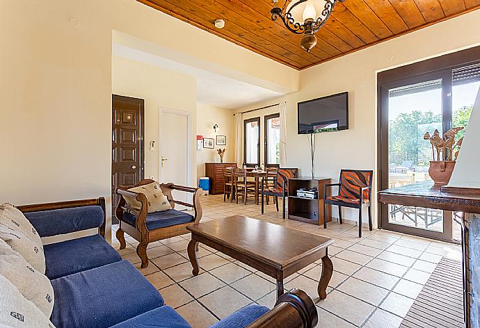 Living room with sofa, dining area, ornamental fireplace, WiFi internet, satellite TV, DVD player, and pool terrace access . - Villa Kefalas . (Galería de imágenes) }}