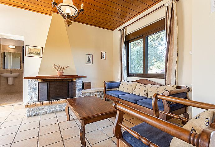 Living room with sofa, dining area, ornamental fireplace, WiFi internet, satellite TV, DVD player, and pool terrace access . - Villa Kefalas . (Galerie de photos) }}