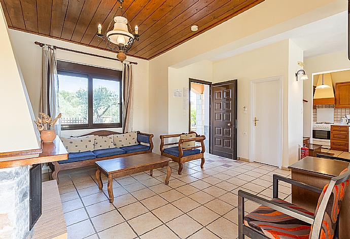 Living room with sofa, dining area, ornamental fireplace, WiFi internet, satellite TV, DVD player, and pool terrace access . - Villa Kefalas . (Galerie de photos) }}