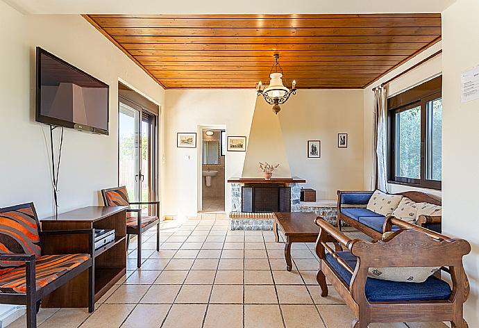 Living room with sofa, dining area, ornamental fireplace, WiFi internet, satellite TV, DVD player, and pool terrace access . - Villa Kefalas . (Galerie de photos) }}